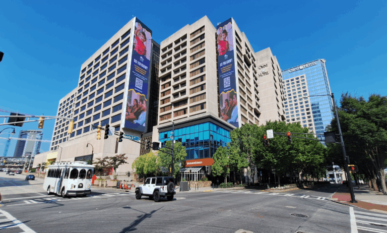 The Center (former CNN Center) under renovation, with cranes, digital billboards, and new public plazas in vibrant downtown Atlanta