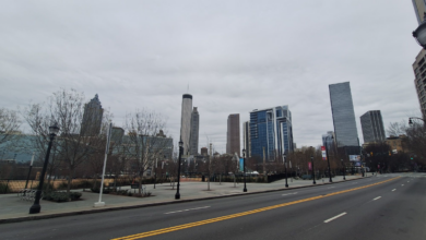 Empty Atlanta skyline under gray winter storm clouds, featuring Bank of America, Truist, and AT&T skyscrapers with bare trees lining a deserted street and sidewalk on January 26, 2026—evoking the quiet isolation of MARTA's bus suspension.